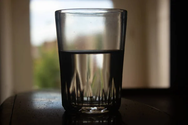 Nahaufnahme Eines Halbvollen Wasserglases Auf Dem Tisch Drinnen — Stockfoto