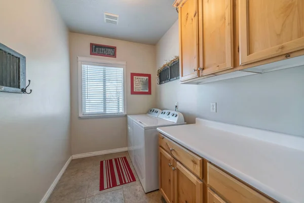 A laundry room with a washing machine, a dryer, and wooden cabinets for clothes