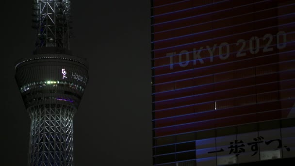 東京2020オリンピック聖火リレーのためにスクロールする 希望の光私たちの道 メッセージを示す夜の東京スカイツリーマーキーの閉鎖 — ストック動画