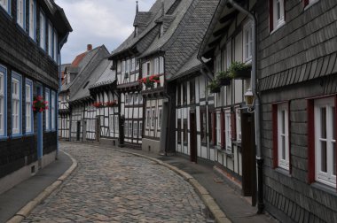 A cobblestone alley between medieval half-timbered houses in the historical town Goslar, Germany clipart