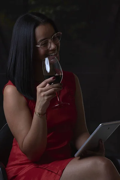 Испанская Женщина Пьет Вино Использует Планшет Изолированный Темном Фоне — стоковое фото