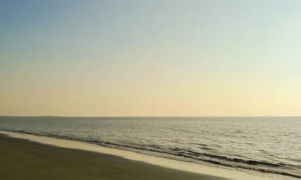 Belo Tiro Uma Praia Areia Oceano Ondulado Com Céu Colorido — Fotografia de Stock