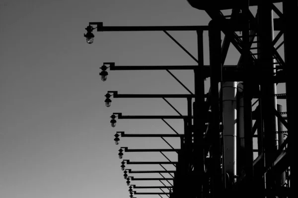 Gökyüzünün Altındaki Bir Fabrikanın Dışındaki Uzun Sokak Lambalarının Düşük Açılı — Stok fotoğraf