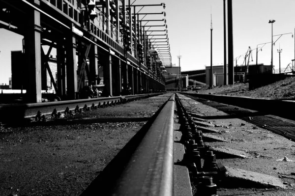 Een Grijswaarden Shot Van Spoorlijnen Zware Metalen Constructies — Stockfoto
