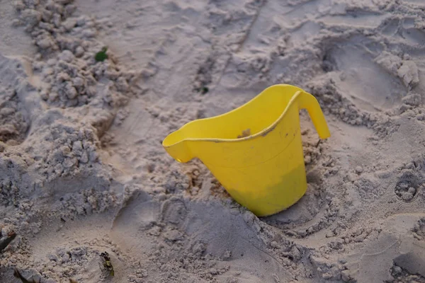 砂の上に黄色のプラスチック製のマグカップの閉鎖 — ストック写真