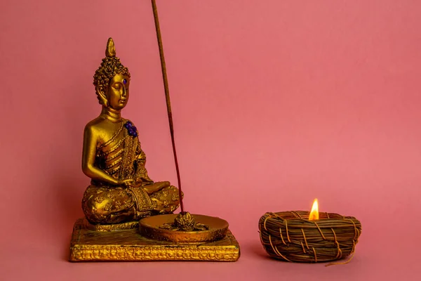 Una Piccola Statuetta Buddha Con Una Candela Accesa Sfondo Rosa — Foto Stock