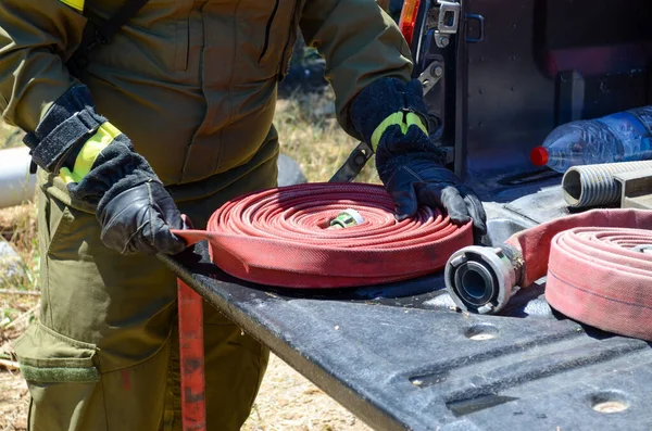 Person Fireman Uniform Packing Red Water Hose Spiral — Stock Photo, Image