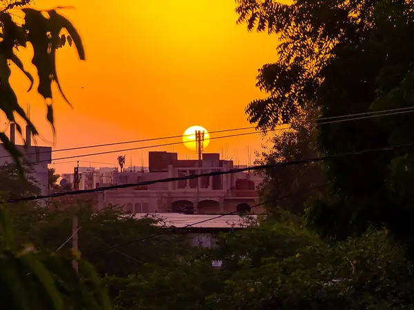 オレンジの空の都市の屋根の上に輝く夕日の素晴らしい景色 — ストック写真