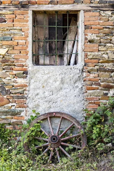 Pionowe Ujęcie Koła Przy Zamkniętym Oknie Murowanym Starym Budynku — Zdjęcie stockowe