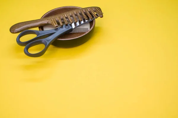 Крупный План Расчёсок Ножниц Деревянной Чаше Жёлтом Фоне — стоковое фото
