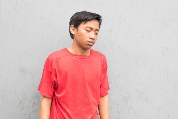 Omtänksam Indonesisk Kille Röd Shirt Mot Grå Vägg — Stockfoto