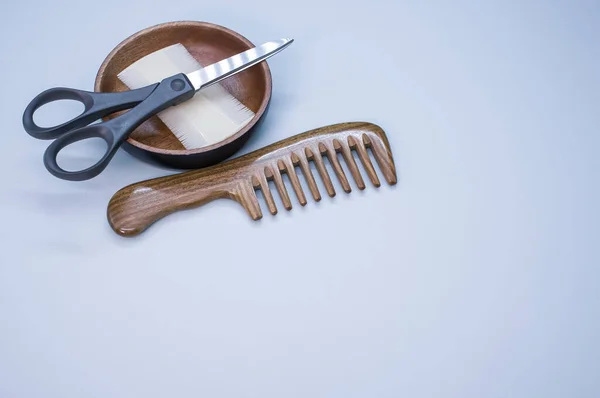Closeup Shot Hairbrushes Scissors Wooden Bowl Blue Background — Stock Photo, Image
