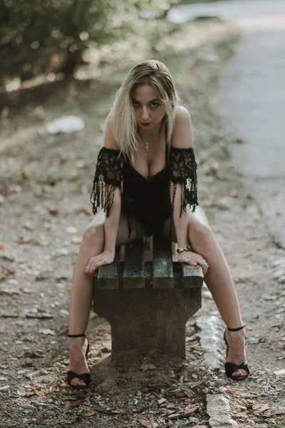 Μια Σέξι Ξανθιά Γυναίκα Ποζάρει Ένα Ξύλινο Παγκάκι Ένα Πάρκο — Φωτογραφία Αρχείου