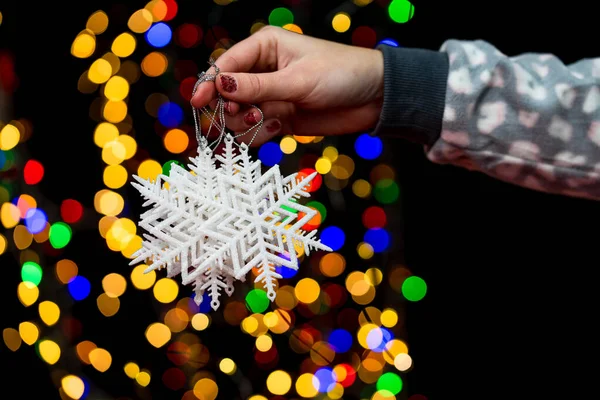 Kvinnlig Hand Som Håller Snöflingor Formade Grannlåt Färgglada Bokeh Ljus — Stockfoto