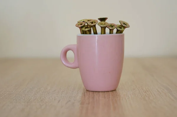 Primer Plano Una Taza Rosa Con Tornillos Mesa —  Fotos de Stock