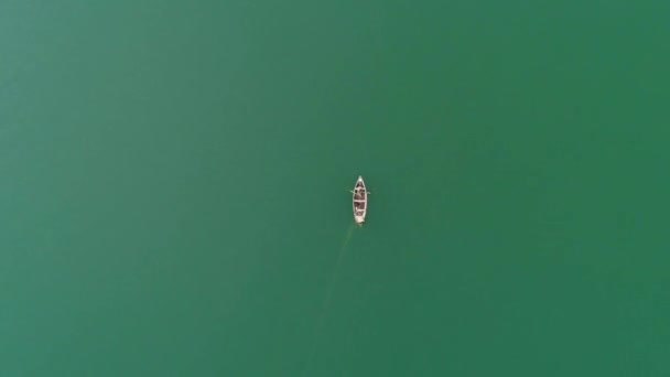 Video Aéreo Barco Madera Mar Verde Claro Con Hombre Pescando — Vídeos de Stock