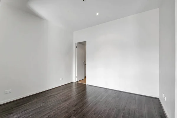 白い壁と灰色のラミネートフロアの空の部屋 — ストック写真