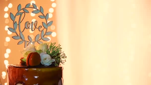 2層のウェディングドリップケーキで愛の手紙と新鮮な花に対してBocheh背景でHd — ストック動画