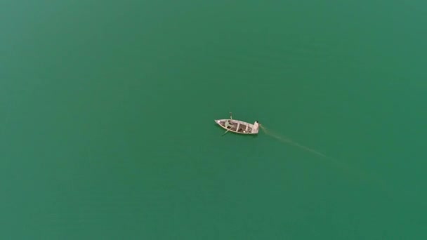 Video Aéreo Barco Madera Cruzando Tranquilo Mar Verde Con Hombre — Vídeo de stock