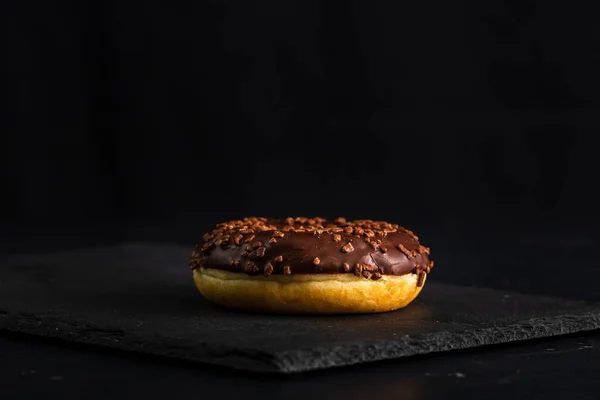 Ένα Σοκολατένιο Ντόνατ Κομματάκια Σοκολάτας Που Απομονώνονται Στο Μαύρο Φόντο — Φωτογραφία Αρχείου