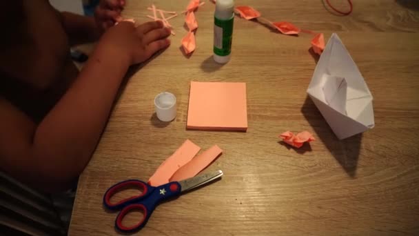Młody Chłopiec Tworząc Łodzie Papieru Pomocą Kleju Nożyczek Wieczorem — Wideo stockowe