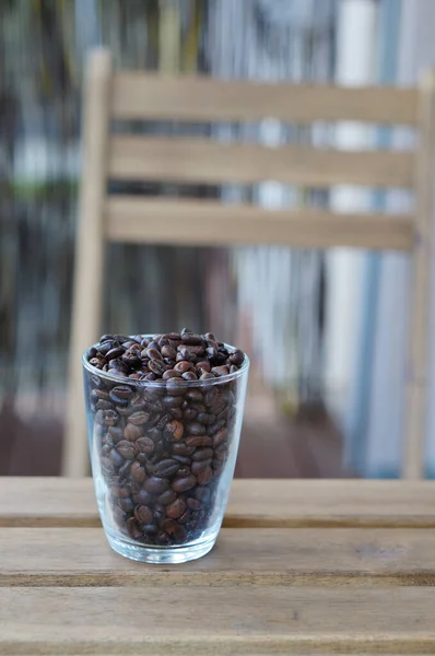 Una Toma Vertical Granos Café Una Taza Vidrio Sobre Fondo — Foto de Stock