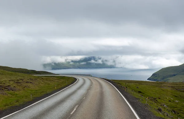 Faroe Adaları Uzanan Bulutlu Arka Planda Asfalt Bir Yolun Manzarası — Stok fotoğraf