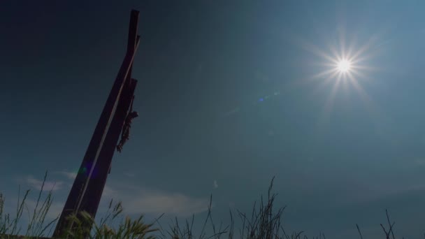 Låg Vinkel Skott Ett Träkors Ett Fält Mot Blå Himmel — Stockvideo