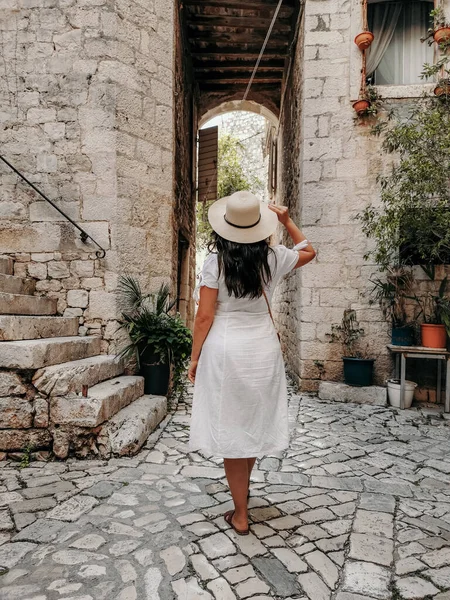 年轻女子身穿白色衣服 头戴太阳帽 手持手提包的后视镜 旧城区女性游客的生活方式与时尚全貌 — 图库照片