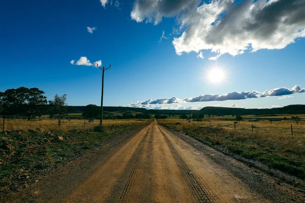 Pohled Malebnou Venkovskou Cestu Poli Obou Stranách Slunečného Oblačného Dne — Stock fotografie