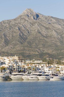 MALAGA, SPAIN - Jan 21, 2021: Puerto Banus, luxury marina, port in Nueva Andalucia, with yachts, La Concha mountain behind, Marbella, Costa del sol, Andalucia, Spain. clipart