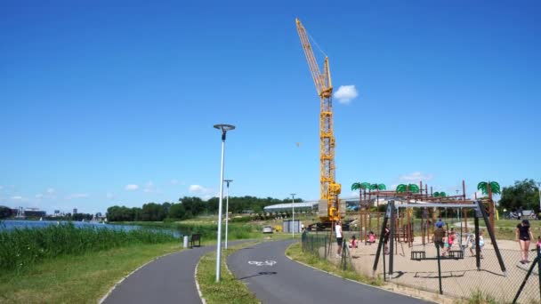 Rad Und Fußweg Neben Einem Spielplatz Mit Einem Hohen Baukran — Stockvideo