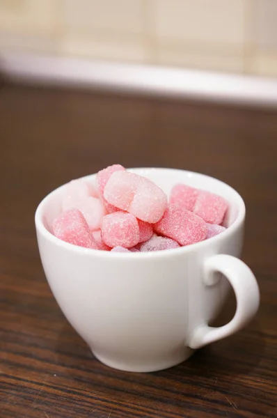 Colpo Verticale Caramelle Rosa Forma Cuore Una Tazza Bianca Tavolo — Foto Stock