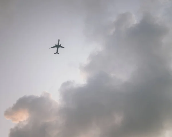 Egy Elszigetelt Repülőgép Repül Sűrű Felhők Mellett — Stock Fotó