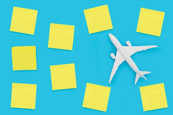 Голубой Фон Белым Самолетом Окружении Желтых Липких Нот — стоковое фото