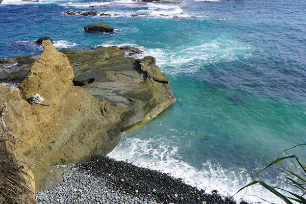 波と明るい青い海の近くの崖の高角度ショット — ストック写真