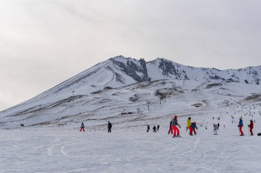 People skiing on the ski slope Kayseri, view of Erciyes, Turkey. clipart