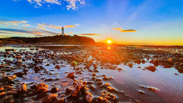 Primer Plano Una Costa Con Faro Fondo Durante Puesta Del — Foto de Stock