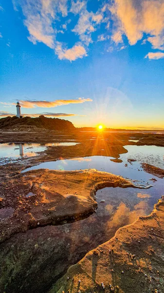 Colpo Verticale Una Spiaggia Rocciosa Con Faro Sullo Sfondo Durante — Foto Stock