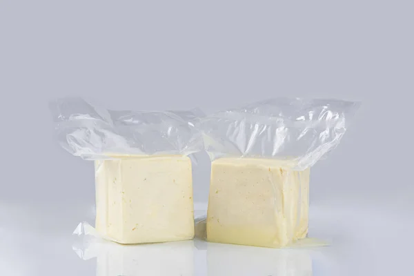Mavi Arka Planda Plastik Bir Torba Içinde Beyaz Peynirin Yakın — Stok fotoğraf