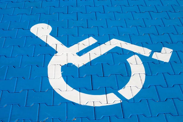 蓝色石路上的残疾停车标志 — 图库照片