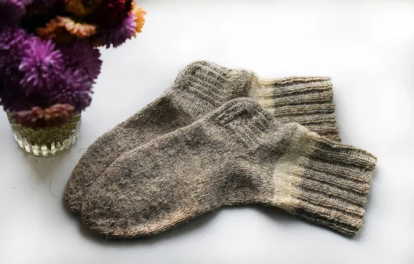 Eine Nahaufnahme Von Gestrickten Wollsocken Und Lila Blumen Einer Transparenten — Stockfoto