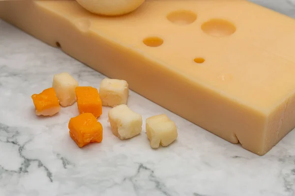 Detailní Záběr Čedaru Malými Sýrovými Čtverečky Mramorovém Povrchu — Stock fotografie