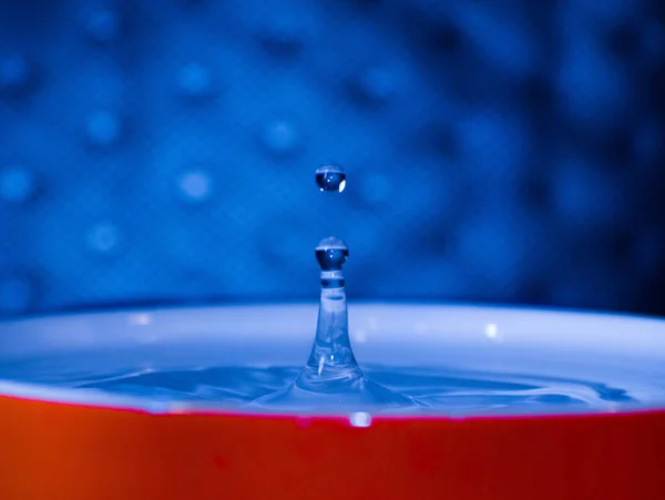 赤いカップの中の水滴の選択的な焦点ショット — ストック写真