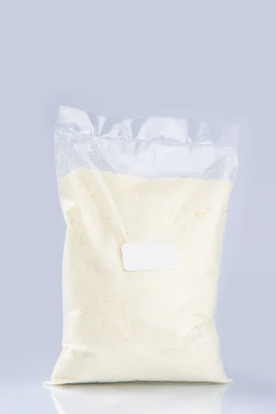 Mavi Arka Planda Plastik Poşette Beyaz Peynirin Dikey Görüntüsü — Stok fotoğraf