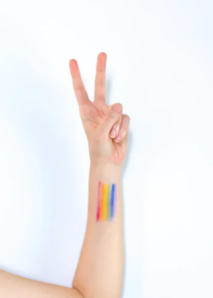 白い背景にLgbtの虹の美学と平和のサインを示す手の垂直ショット — ストック写真