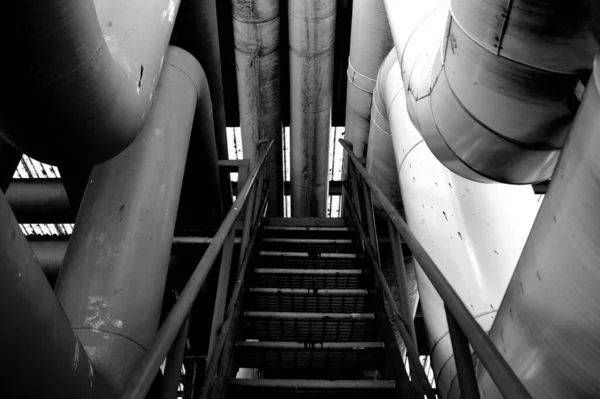 隔着金属管穿过的楼梯的灰度照片 — 图库照片