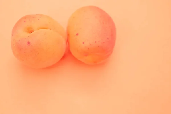 Spazio Copia Due Albicocche Rosate Uno Sfondo Rosa Arancio — Foto Stock