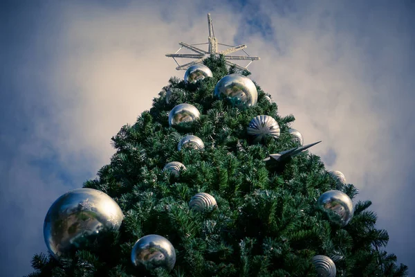 曇った空に対して美しい装飾が施されたクリスマスツリーの低角度ショット — ストック写真