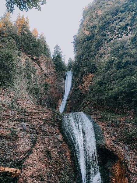 Eine Vertikale Aufnahme Eines Wasserfalls Den Bewaldeten Bergen — Stockfoto